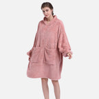 Femme portant un poncho polaire rose avec capuche, manches longues et poche ventrale