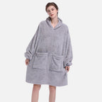 Femme portant un poncho polaire gris capuche avec manches longues et poche ventrale