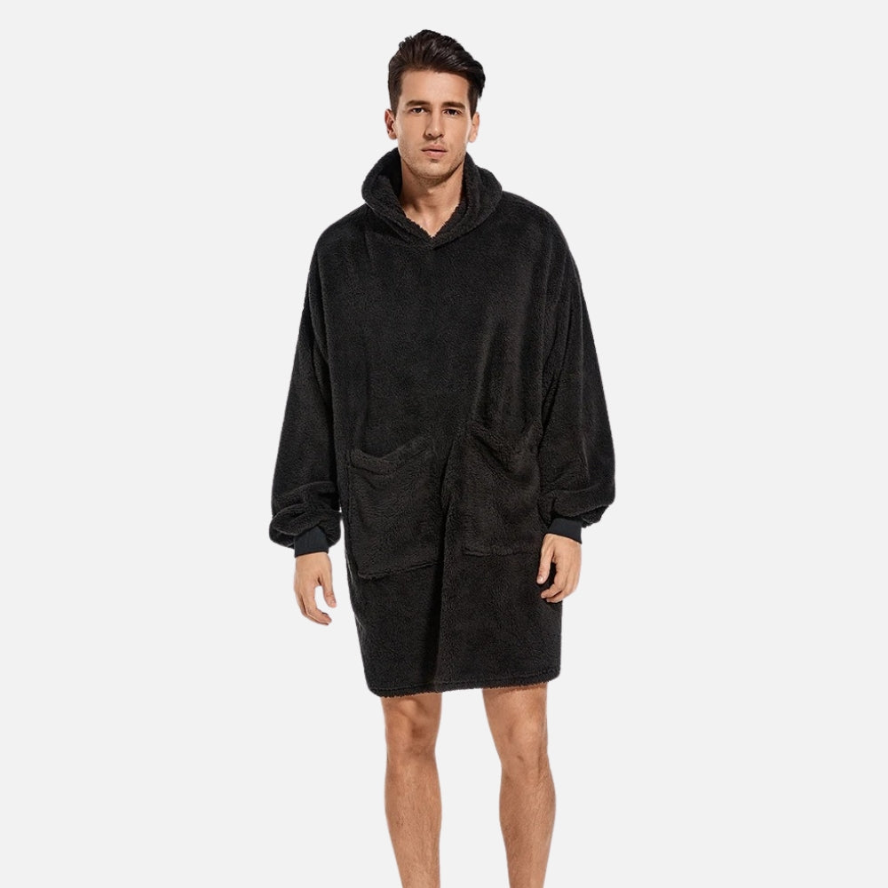 Homme portant poncho polaire noir avec capuche et poches, coupe ample vue de face