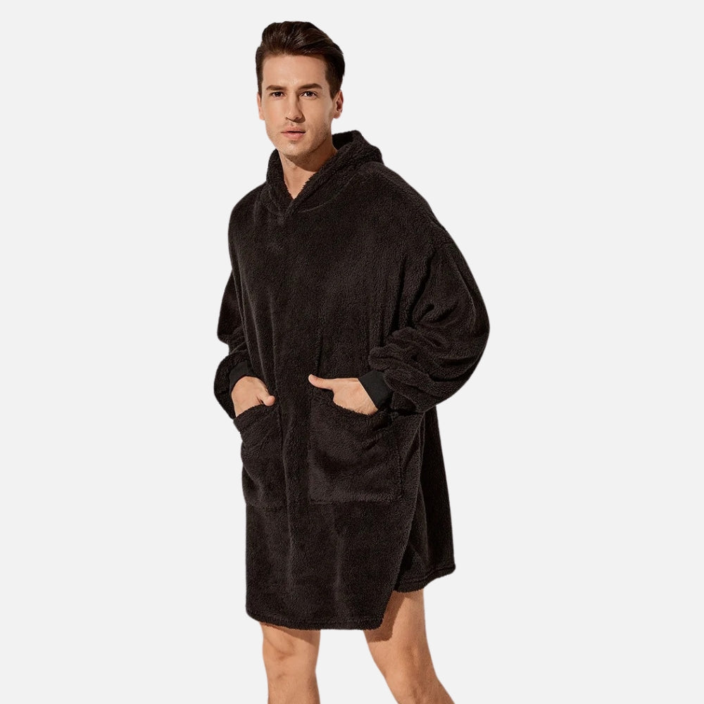 Homme portant poncho polaire noir à capuche avec poches et coupe ample vue de face