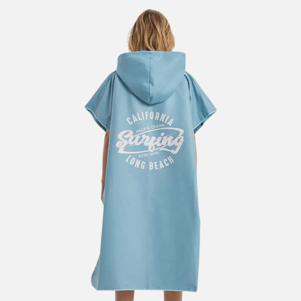 Femme portant poncho surf microfibre bleu avec capuche et motif surfing Long Beach
