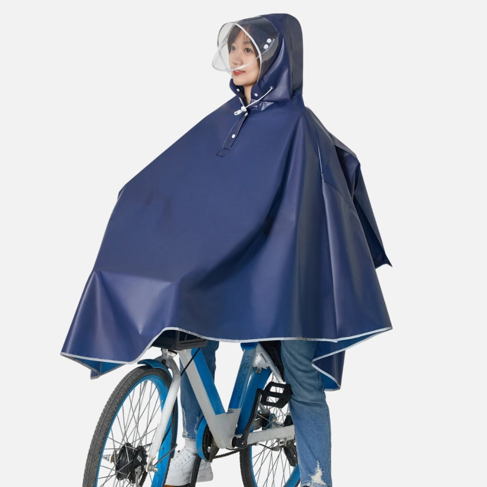 Femme à vélo portant poncho bleu marine avec visière transparente et liseré réfléchissant