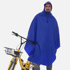 Homme portant poncho vélo bleu avec capuche et cordon, à côté d'un vélo jaune