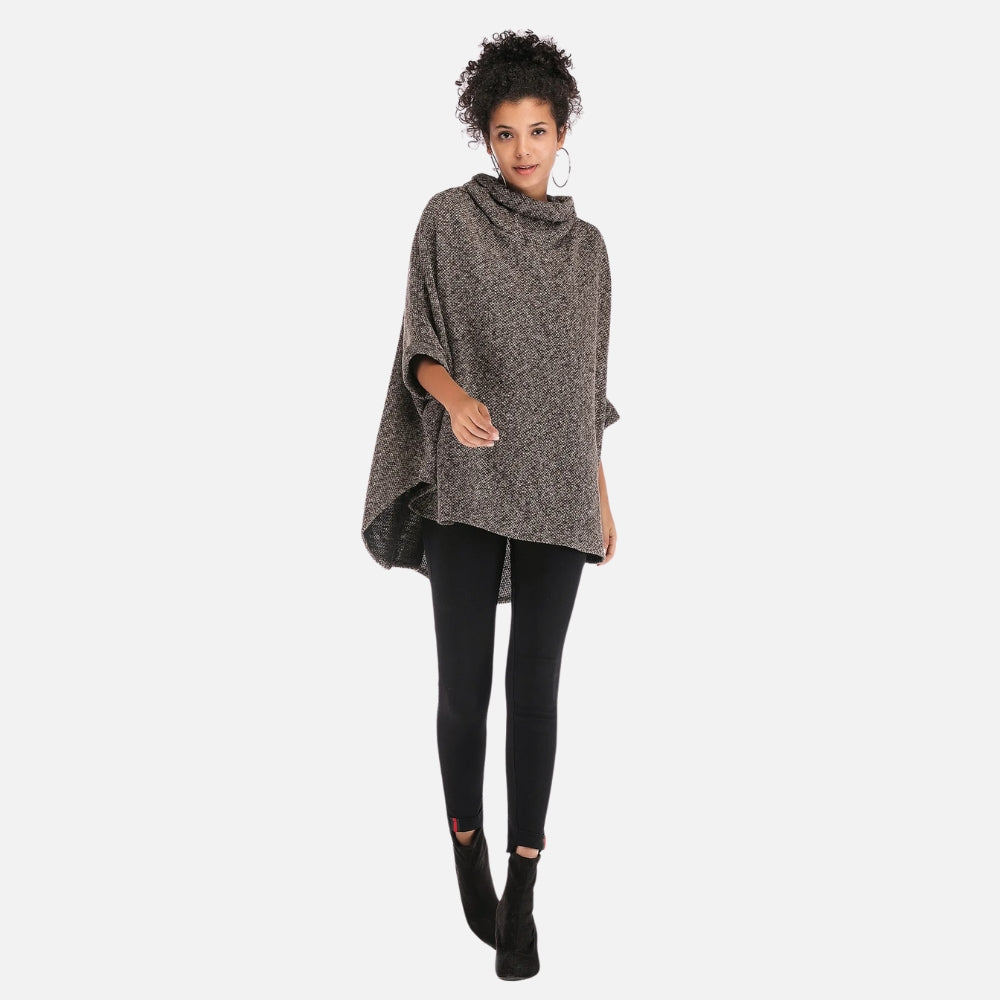 Femme portant un poncho pull gris chiné col roulé avec leggings noirs déchirés