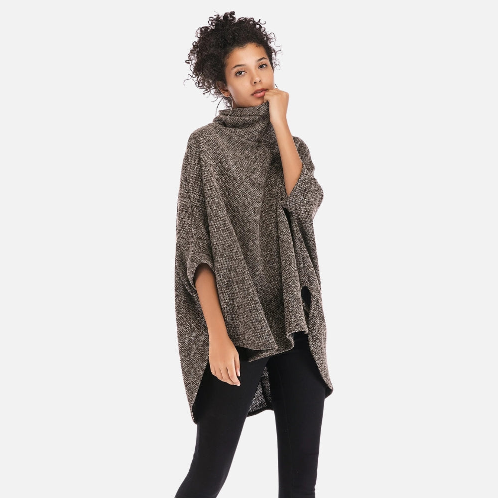 Femme portant un pull poncho col roulé gris chiné manches trois-quarts avec pantalon noir