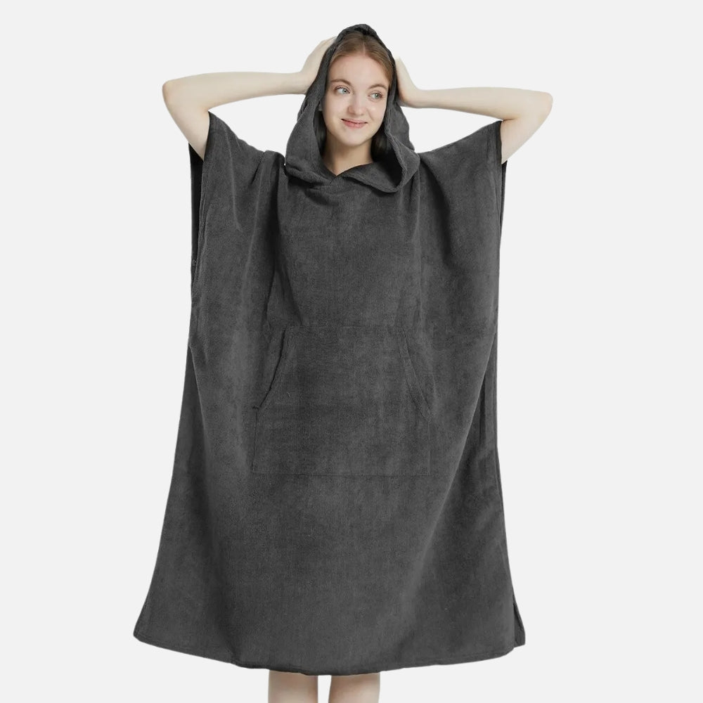 Femme portant serviette poncho microfibre grise avec capuche et poche, bras levés